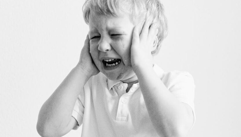 grayscale photo of a boy crying