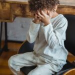 african american boy sitting in chair and crying
