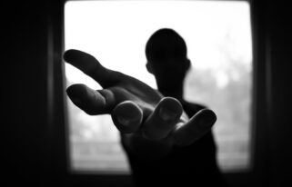 man s hand in shallow focus and grayscale photography