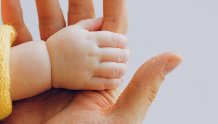 person holding babys hand