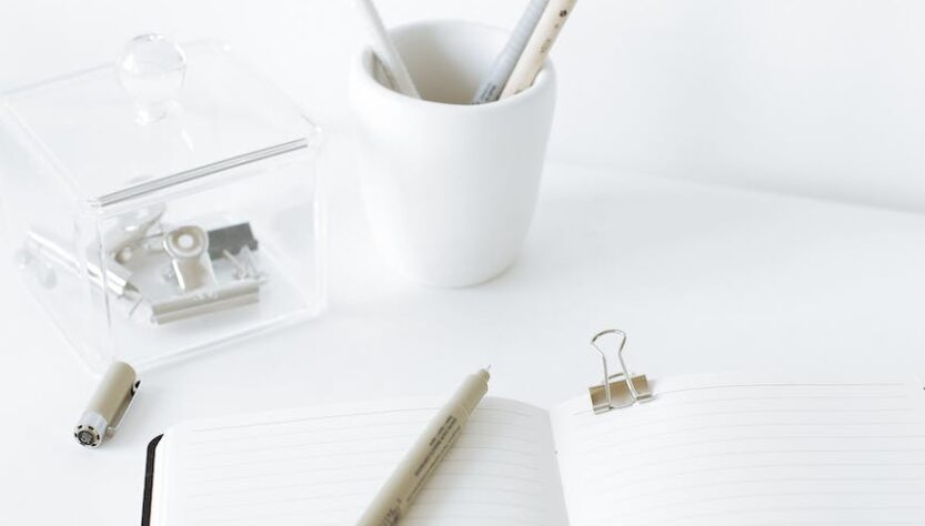 opened notebook with pen on white desk